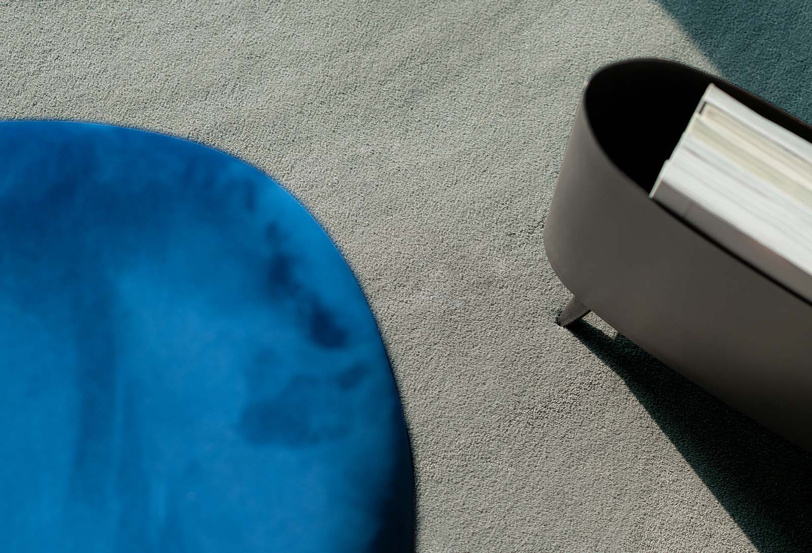 Donkergrijs vloerkleed op maat met blauwe stoel