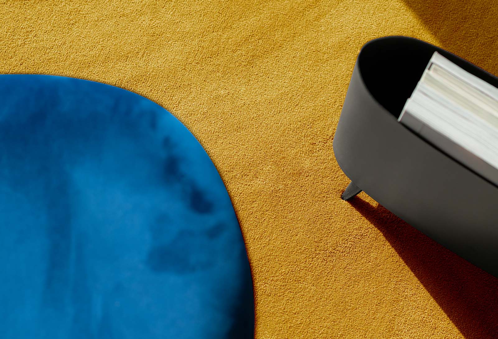Geel vloerkleed op maat met blauwe stoel